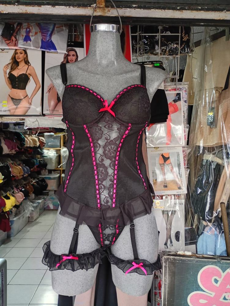 Corsé negro con listón rosa y liguero en el maniquí
